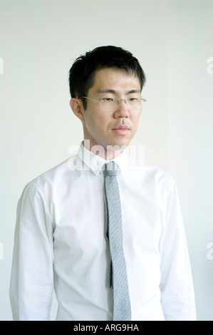 Portrait young Asian Businessman in Medium Shot "Looking Down" off Camera Dressed in "White Shirt and Tie" "White Background" Stock Photo