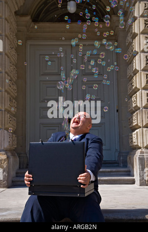 Businessman with Bubbles Coming out of Briefcase Stock Photo
