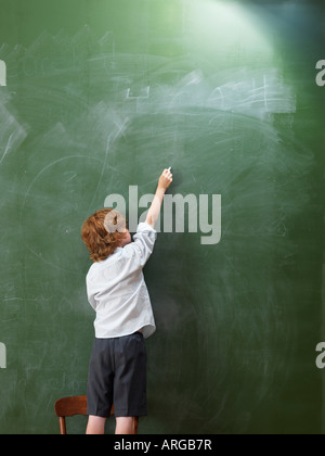 Boy Writing on Blackboard Stock Photo