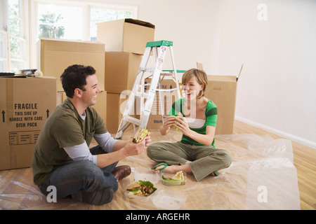 Couple Eating Sandwiches in New Home Stock Photo