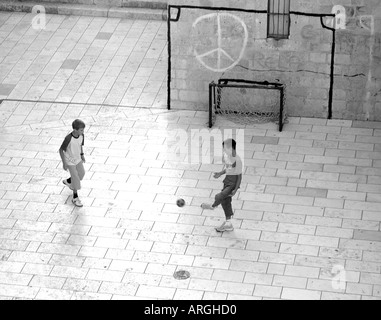 Two Kids playing urban football in Dubrovnik Centre in Croatia Stock Photo