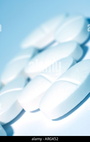 Small white medicinal tablets with fresh blue toning Stock Photo