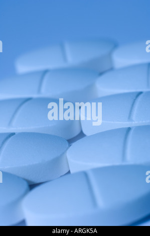 Small white medicinal tablets with fresh blue toning Stock Photo