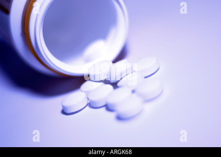 Small white medicinal tablets with fresh violet toning Stock Photo