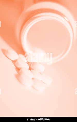 Small white medicinal tablets with fresh orange toning Stock Photo