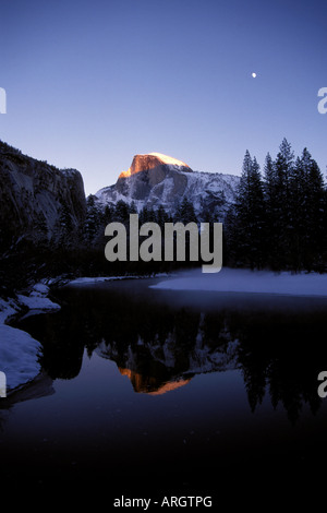Dawn begins to light up Half Dome on a winter morning at Yosemite National Park in California.