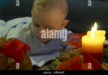 baby lying in front of Advent wreath Stock Photo