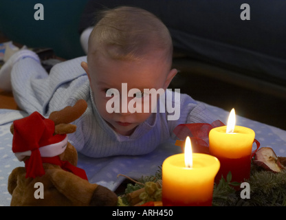 baby lying in front of Advent wreath Stock Photo