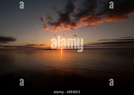 A general view of the sun setting over the town of Portmarnock pictured in Ireland. The sun is setting out to sea. Stock Photo