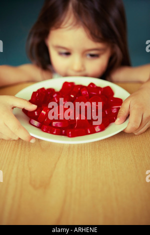 Girl looks down at plate of heart shaped sweets Stock Photo