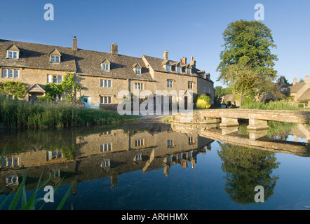 A view of traditional cotswold cottages in evening light, reflected in the river Eye at Lower Slaughter in Gloucestershire, UK Stock Photo