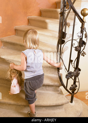 Little girl climbing up the stairs Stock Photo