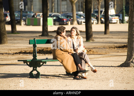 Two friends having a chat on a park bench in the champ de mars Paris France Stock Photo