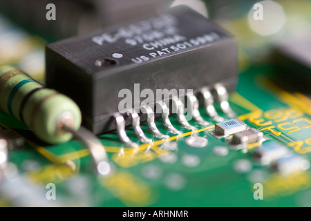 Macro close up of integrated circuit chip mounted on printed circuit board showing electronic components and soldered pins in computer hardware. Stock Photo
