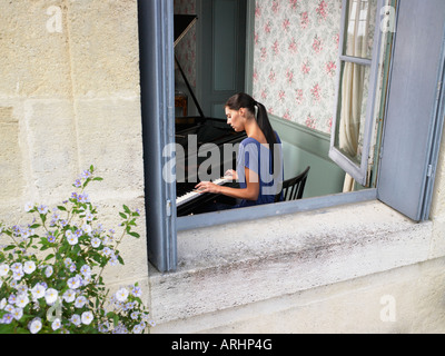 Woman playing piano Stock Photo