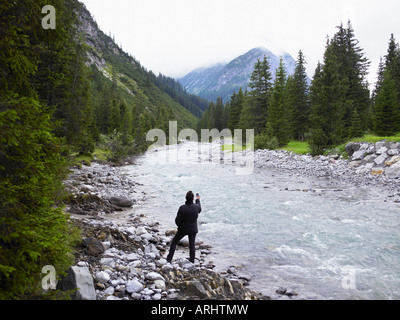 Woman taking pictures of a river Stock Photo