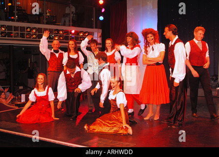 Mediterranean sea on board cruise ship entertainment team wave farewell in the theatre at end of trip after final performance Stock Photo
