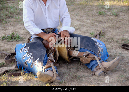 Cowboy practices holding onto his saddle prior to a bronco riding event at a Rodeo Stock Photo