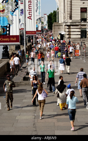 Crowd walking along The Queens Walk South Bank London Stock Photo