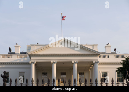 Two Secret Service agents looking back with binoculars from the roof of the White House Washington DC Stock Photo