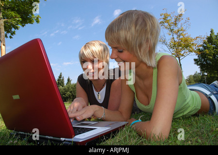 junge Mädchen mit laptop young  auf wiese - girls lying in the grass working with notebook Stock Photo