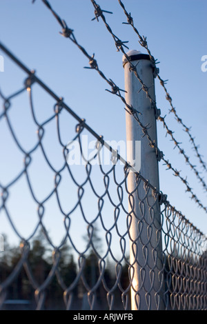 Metal fence with barbed wire Stock Photo