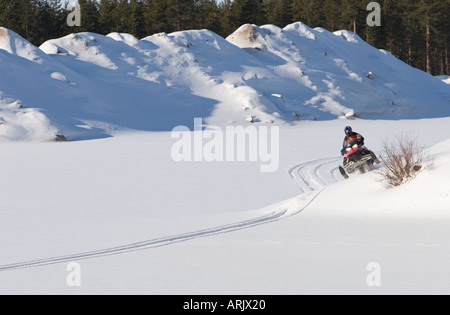 Young man driving snowmobile at Winter , Finland Stock Photo