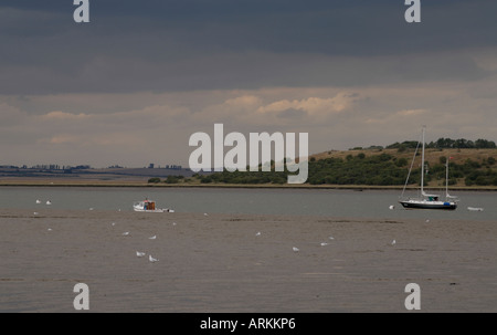 Boats moored in the Swale in the Thames estuary on a stormy evening Oare Faversham Kent UK 10 August 2006 Stock Photo