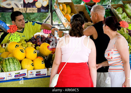Tourist Shoppers paying at Fruit and Vegetable stall in San Fernando Market, Gran Canaria Stock Photo