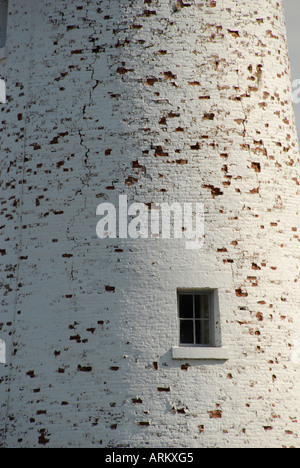 Pealing white paint on a brick wall with a window in it Stock Photo