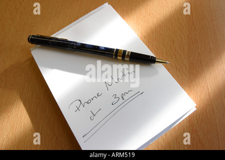 Message written on notepad with pen on desktop reminder to make Phone Call at 3pm Stock Photo