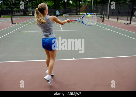 Middle school and high school age teenagers take Tennis lesson in a summer enrichment and development public city program Stock Photo