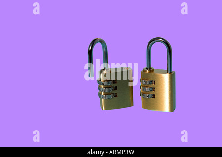 Two combination padlocks on purple background. Stock Photo