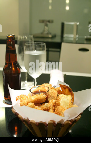 Snack basket of fried calamari and potato chips restaurant setting Stock Photo