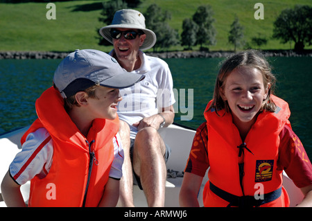 children and father in a row boat lon a lake laughing and having fun Stock Photo