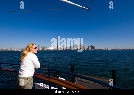 Young woman looks across lake Ontario to downtown from Islands ferry boat, Toronto, Ontario, Canada. Stock Photo