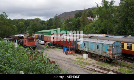 A collection of old style vintage railway carriages and wagons in the sidings waiting to be restored. Wales, UK. Stock Photo