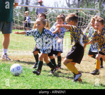 Boys and girls playing team soccer together in California city park Stock Photo