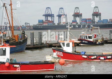 Fishing boats in Harwich port (foreground) and Felixstowe container port, Essex, England, UK. Stock Photo