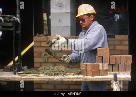 Construction worker. Bricklayer applies mortar while constructing brick wall, British Columbia, Canada. Stock Photo