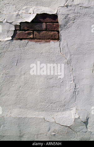 Detail of a painted wall showing exposed brick. Stock Photo
