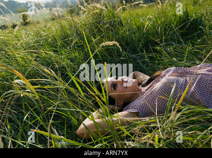 Young woman lying on grass in park Stock Photo - Alamy