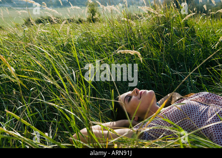 Young woman lying on grass in park Stock Photo - Alamy