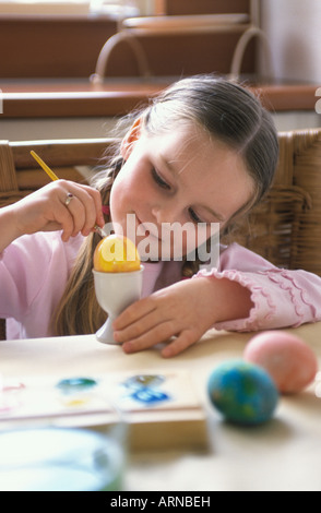 Girl is painting an easter egg Stock Photo