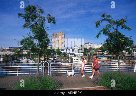 Couple on part of walkway with dog - Bastion beyond, Nanaimo Harbour, Vancouver Island, British Columbia, Canada. Stock Photo