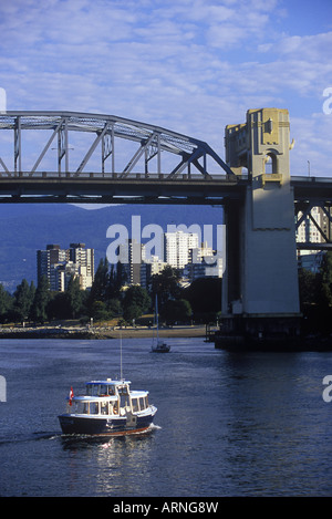 Burrard bridge frames view to West End, with small passenger ferry, Vancouver, British Columbia, Canada. Stock Photo