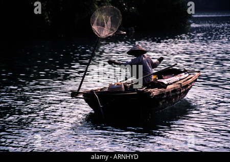 Two men fishing from small boat with net and paddle Yen River leading to  Perfume Pagoda near Hanoi north Vietnam Stock Photo - Alamy