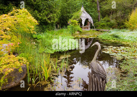 Tofino Botanical Gardens lily pond with wood sculpture, Vancouver Island, British Columbia, Canada. Stock Photo