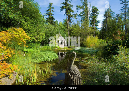 Tofino Botanical Gardens lily pond with wood sculpture, Vancouver Island, British Columbia, Canada. Stock Photo