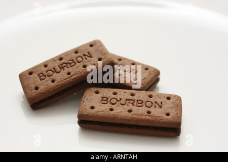 Three Bourbon biscuits arranged on a white plate Stock Photo